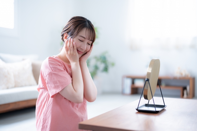 出産祝いでもらったスキンケアしながら満足顔の産後ママ